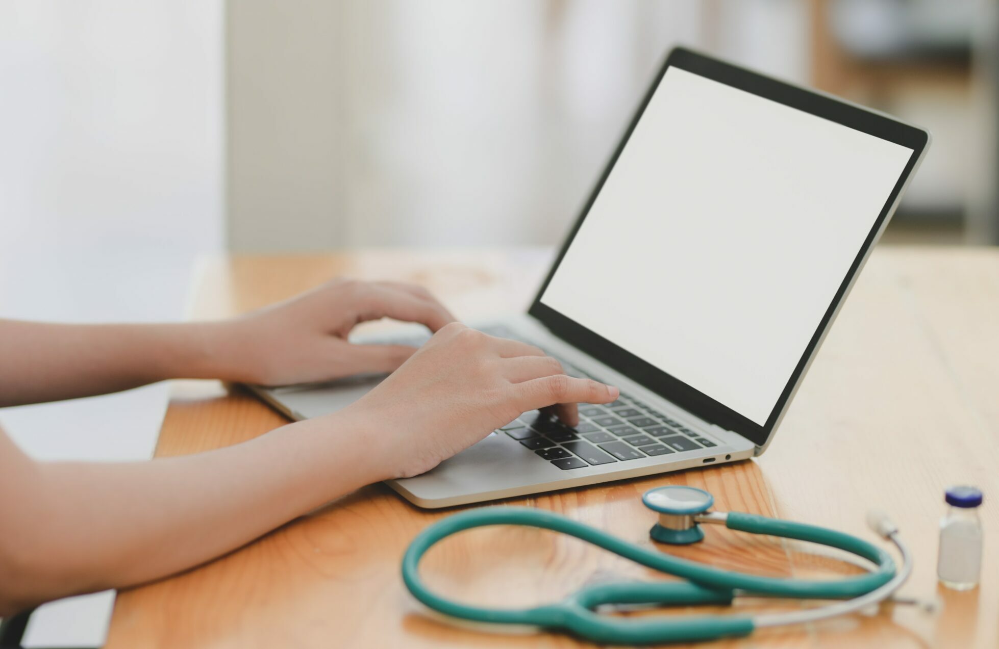 laptop-near-teal-stethoscope-in-wooden-table-3758756